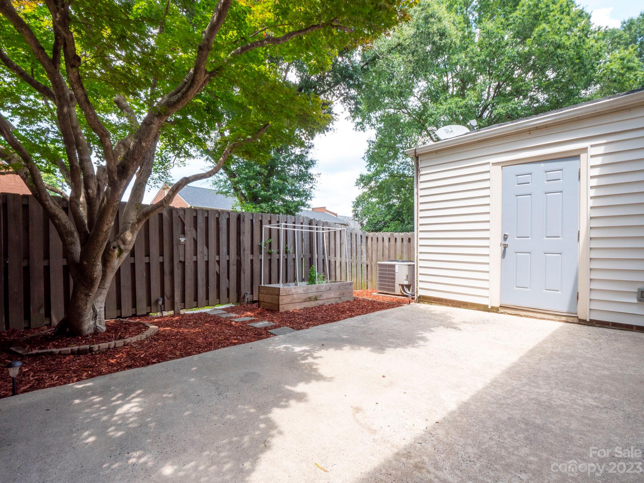 8072 Knights Bridge Road Charlotte, NC 28210 - Photo 19 of 23 a backyard of a house with wooden fence and large trees