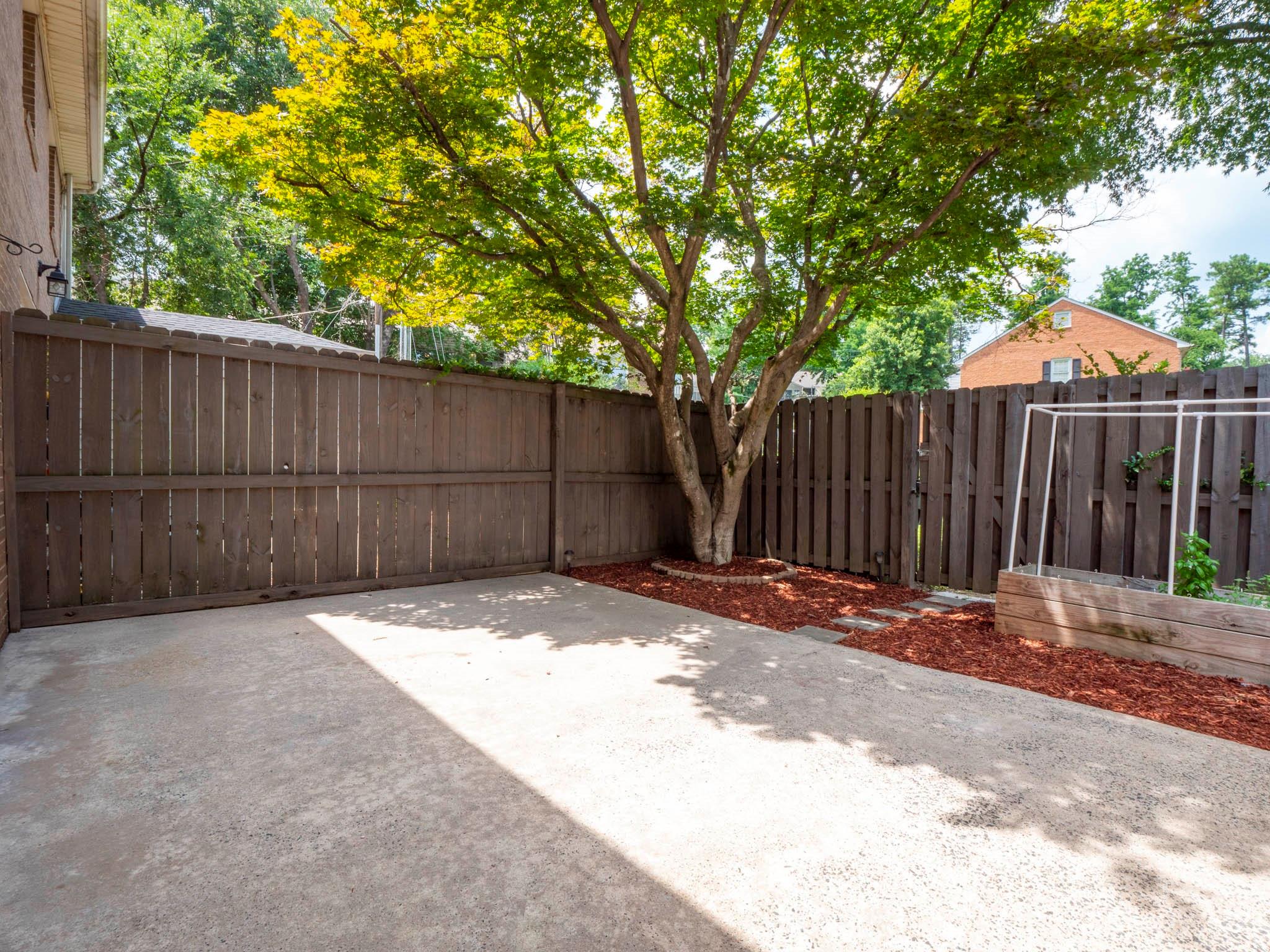 8072 Knights Bridge Road Charlotte, NC 28210 - Photo 20 of 23 a backyard of a house with trees and wooden fence