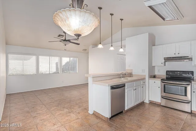 a kitchen with stainless steel appliances granite countertop a stove a sink and a refrigerator