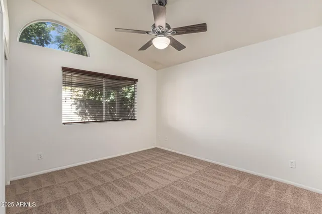 an empty room with a window and a ceiling fan
