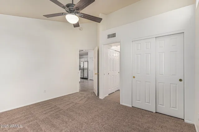 an empty room with closet and fan