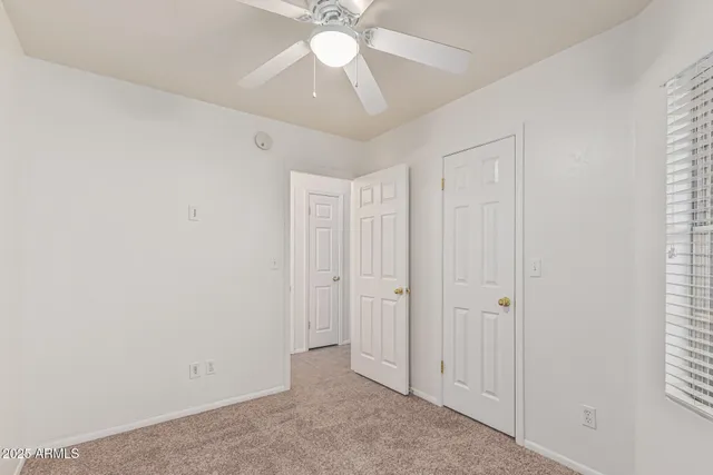 an empty room with fan and windows
