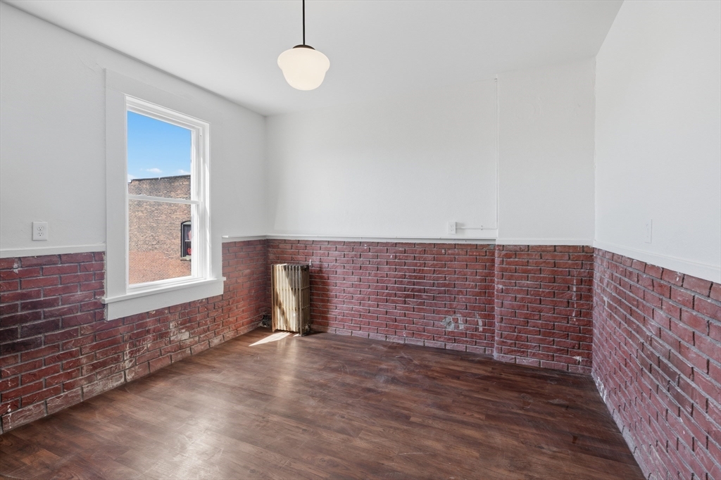 105 High Street, Unit 4P Holyoke, MA 01040 - Photo 5 of 11 a view of an empty room with wooden floor and a window