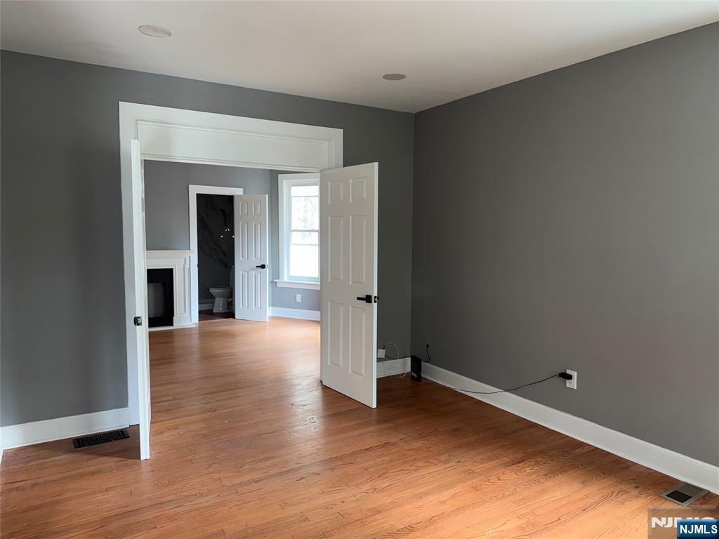 178 Berry Street Hackensack, NJ 07601 - Photo 4 of 22 a view of an empty room with wooden floor and a window