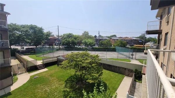 a view of a swimming pool with a bench and trees in the background