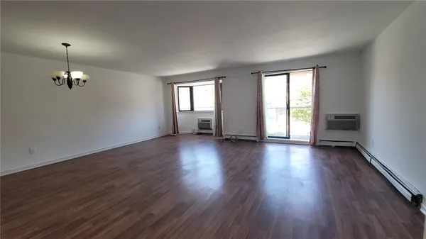 an empty room with wooden floor and window