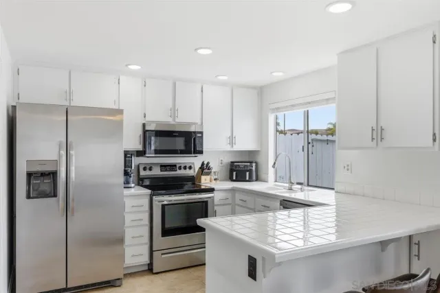 a kitchen with kitchen island stainless steel appliances a sink stove and refrigerator