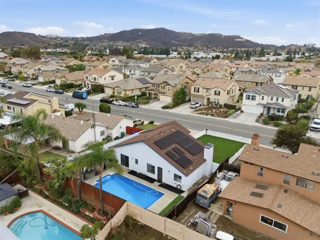 an aerial view of residential houses with outdoor space and street view