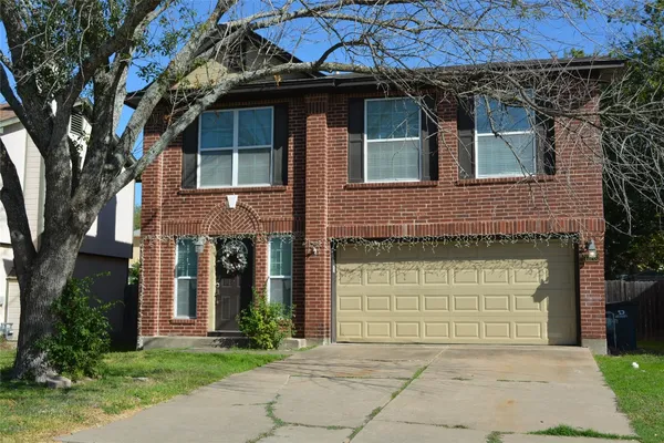 a front view of a house with a garden and garage