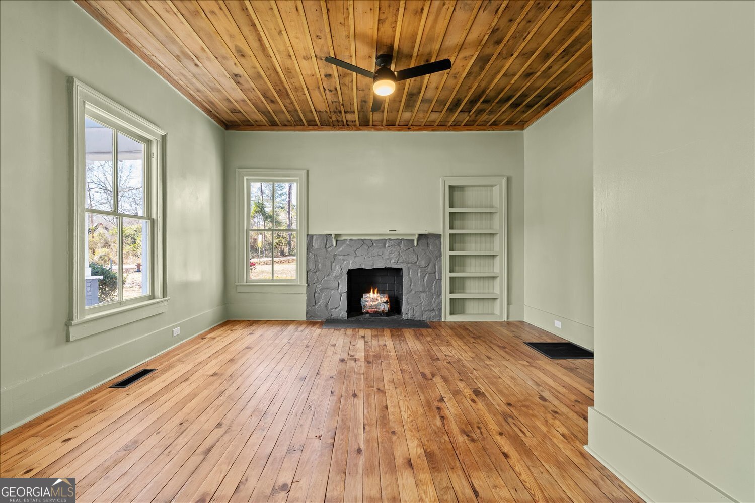528 North Alexander Avenue Washington, GA 30673 - Photo 5 of 42 a view of an empty room with wooden floor fireplace and a window