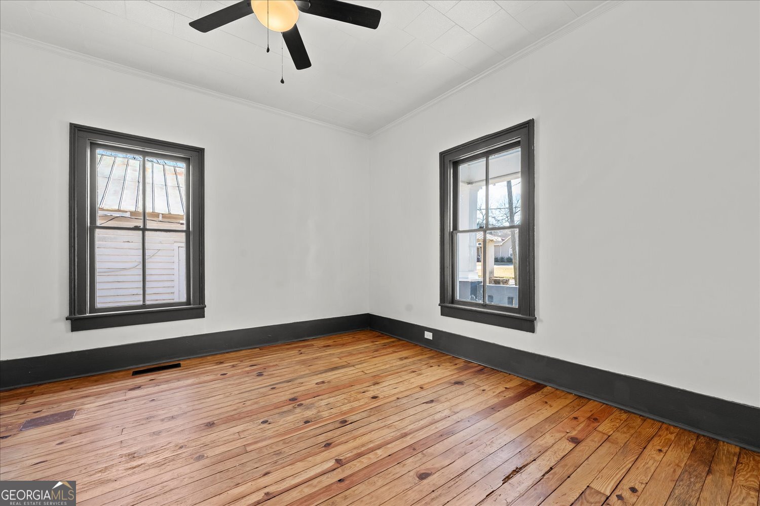 528 North Alexander Avenue Washington, GA 30673 - Photo 7 of 42 a view of an empty room with wooden floor and a window