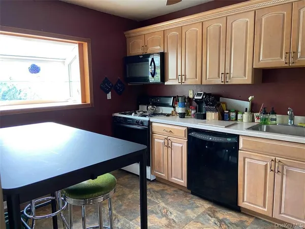 a kitchen with a wooden cabinets appliances and a window