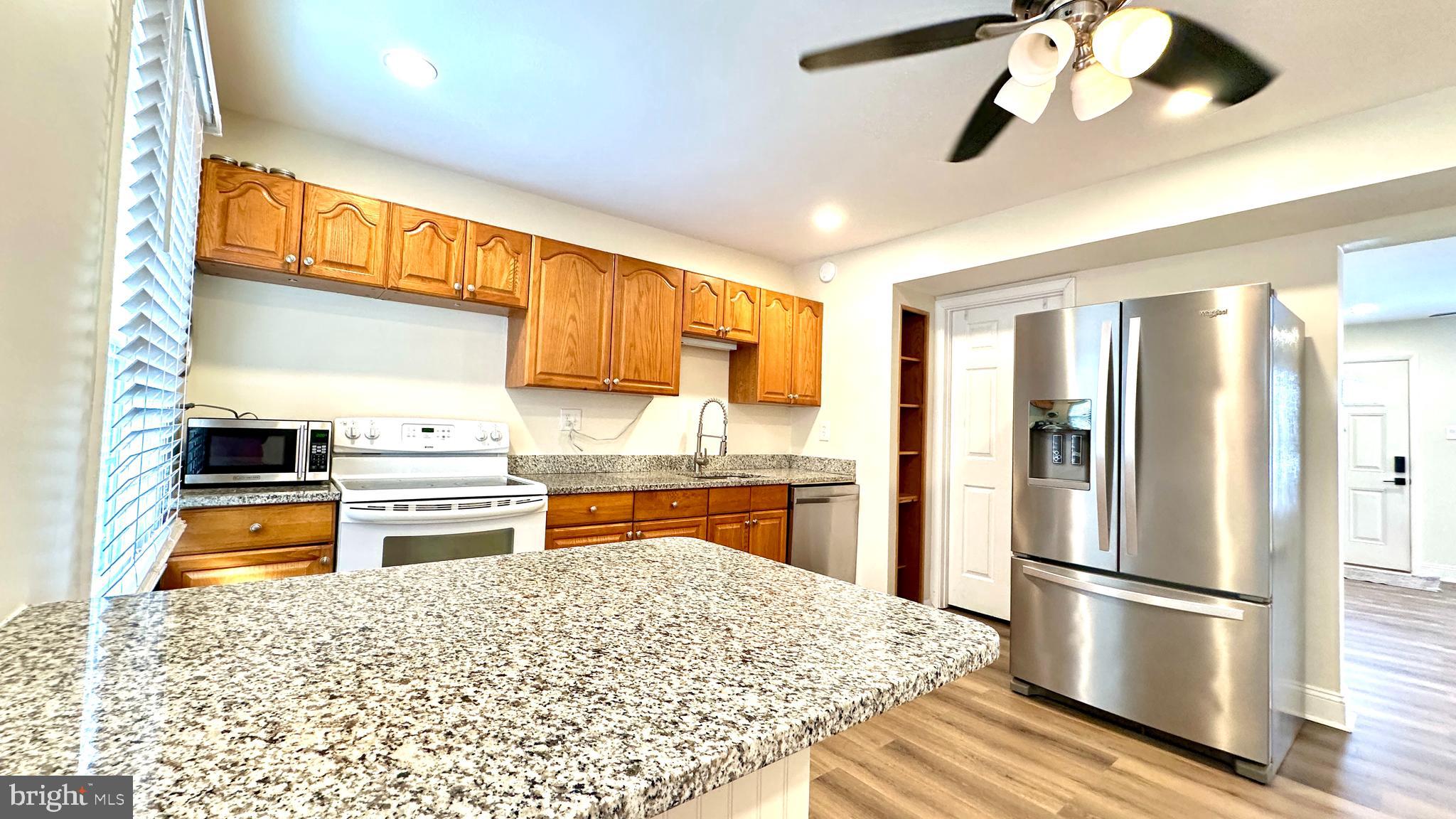 3423 Santee Road Nottingham, MD 21236 - Photo 7 of 30 a kitchen with stainless steel appliances granite countertop a refrigerator a stove and a sink with cabinets