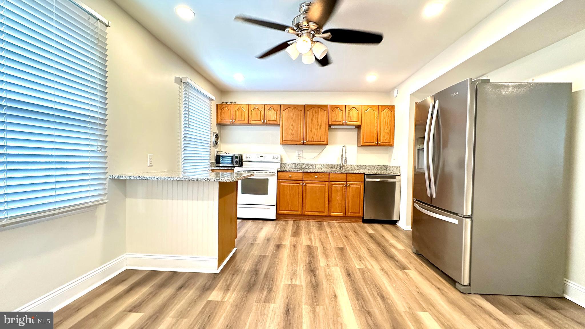 3423 Santee Road Nottingham, MD 21236 - Photo 10 of 30 a kitchen with stainless steel appliances granite countertop a refrigerator a sink and white cabinets
