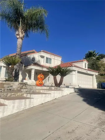 a view of a house with a yard and a car park