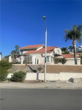 a front view of a house with garden and plants