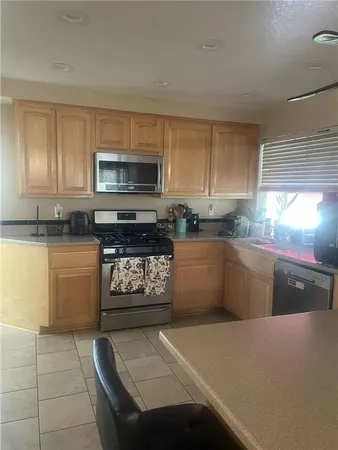 a kitchen with stainless steel appliances kitchen island granite countertop a stove a sink and a microwave