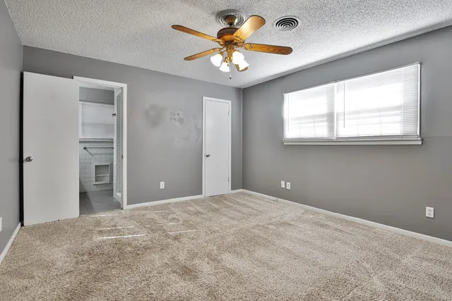 a view of a livingroom with a chandelier fan and a window