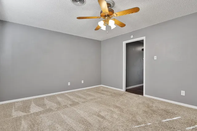 an empty room with a chandelier fan