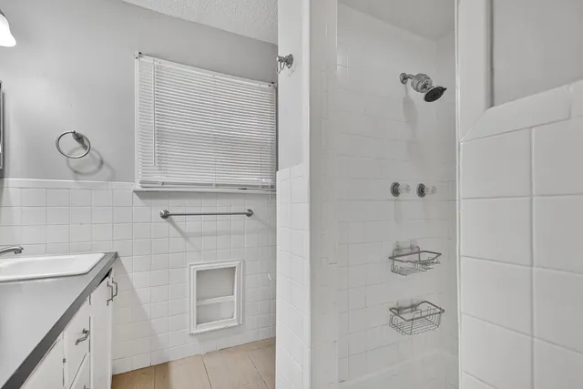 a bathroom with a shower sink and mirror