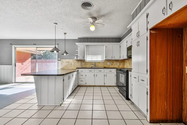 a kitchen with a refrigerator a sink dishwasher and wooden cabinets