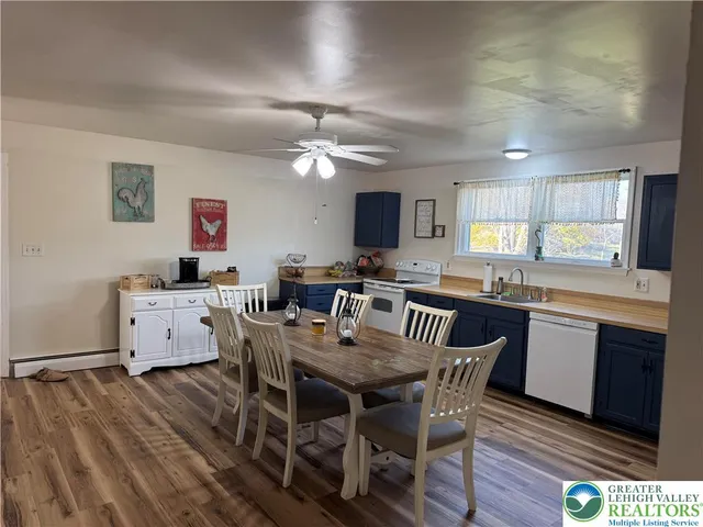 a kitchen with a dining table chairs and refrigerator