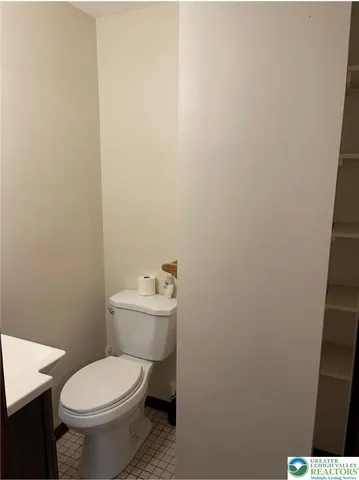 a white toilet sitting next to a white sink and vanity