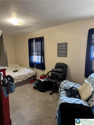 a bedroom with bed couch and window