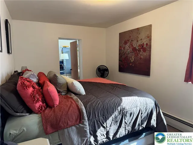 a bedroom with a bed and a painting on the wall