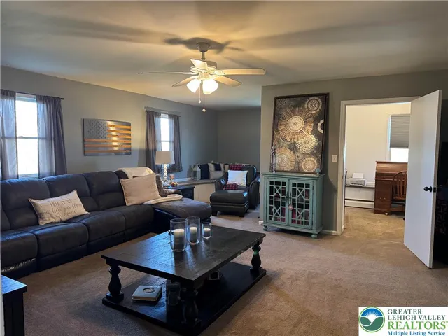 a living room with furniture a chandelier and a flat screen tv