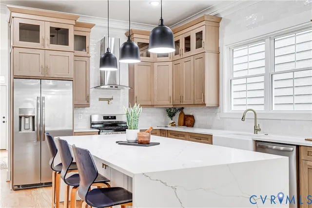 a kitchen with stainless steel appliances a sink a stove and a refrigerator with wooden floor