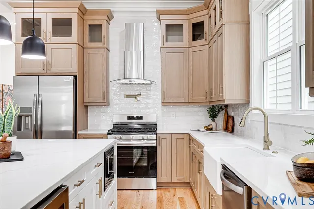 a kitchen with stainless steel appliances a stove a sink and a refrigerator