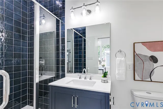 a bathroom with a sink mirror vanity and toilet