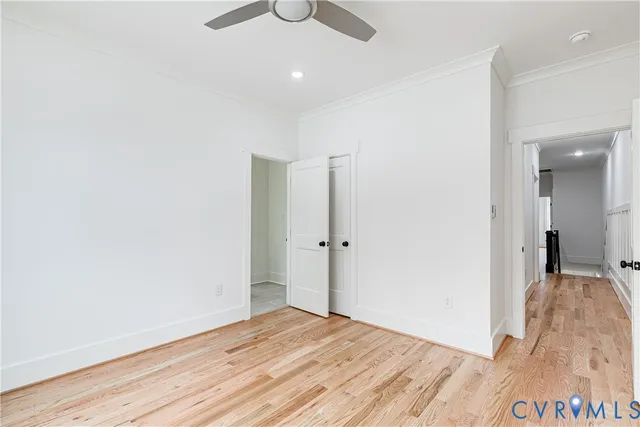 a view of a room with wooden floor and ceiling fan