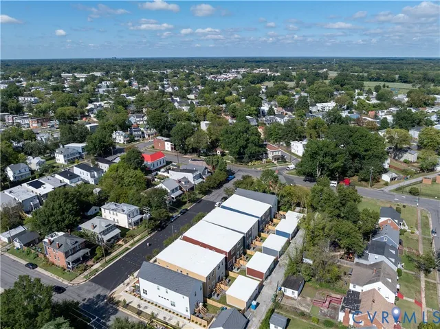 an aerial view of residential houses with outdoor space and trees