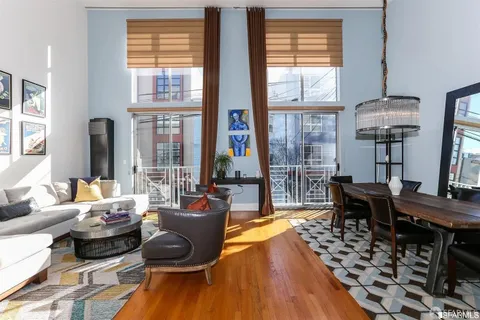 a living room with furniture floor to ceiling window and wooden floor