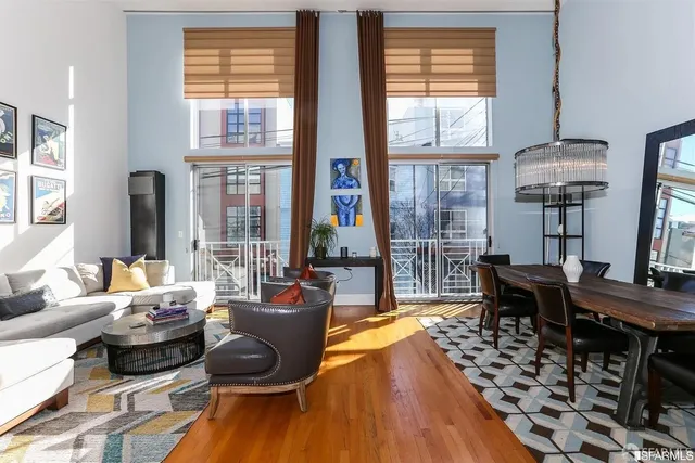 a living room with furniture floor to ceiling window and wooden floor