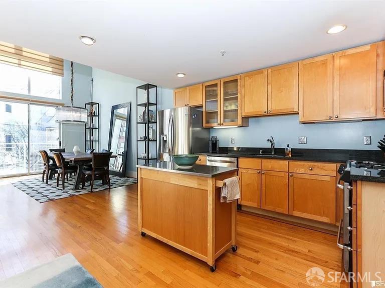 468 Tehama Street, Unit 11 San Francisco, CA 94103 - Photo 2 of 3 a kitchen with stainless steel appliances granite countertop a stove top oven a sink dishwasher and cabinets with wooden floor