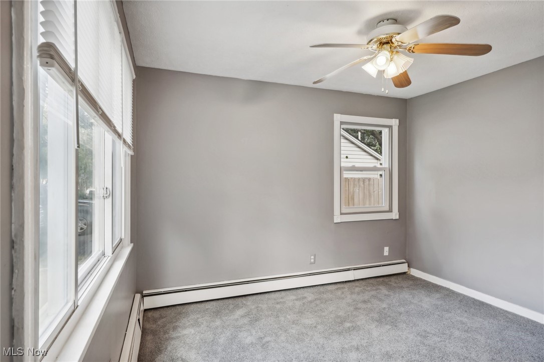 1829 Clyde Road Madison, OH 44057 - Photo 25 of 40 Spare room featuring a baseboard heating unit, ceiling fan, and carpet floors