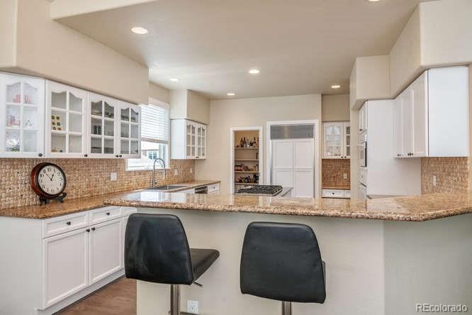 877 Eldorado Drive Superior, CO 80027 - Photo 11 of 34 a kitchen with stainless steel appliances granite countertop a sink a stove and a refrigerator