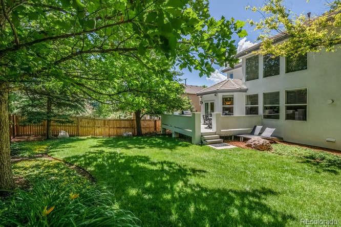 877 Eldorado Drive Superior, CO 80027 - Photo 30 of 34 a backyard of a house with table and chairs and a large tree