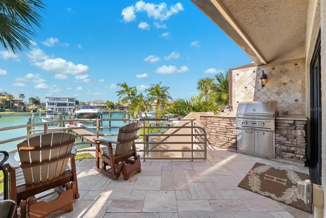 a kitchen with stainless steel appliances granite countertop a refrigerator a sink dishwasher a dining table and chairs with wooden floor