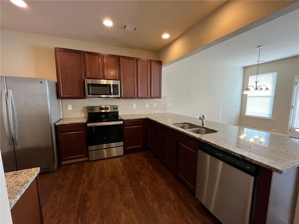a kitchen with granite countertop stainless steel appliances and wooden cabinets