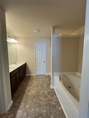 a spacious bathroom with a bathtub sink and mirror