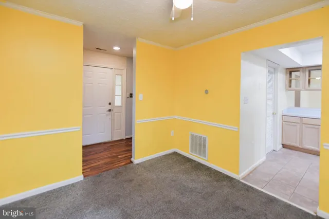 an empty room with a window and a ceiling fan