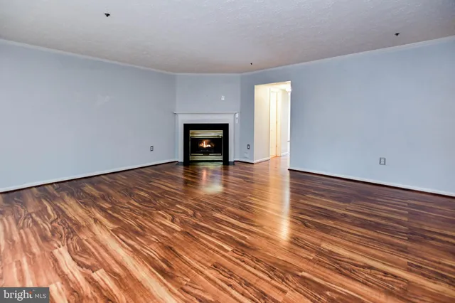 a hallway with wooden floor a fireplace and entryway