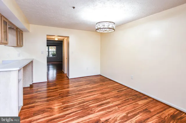 a large kitchen with granite countertop a stove a sink dishwasher and a wooden floor