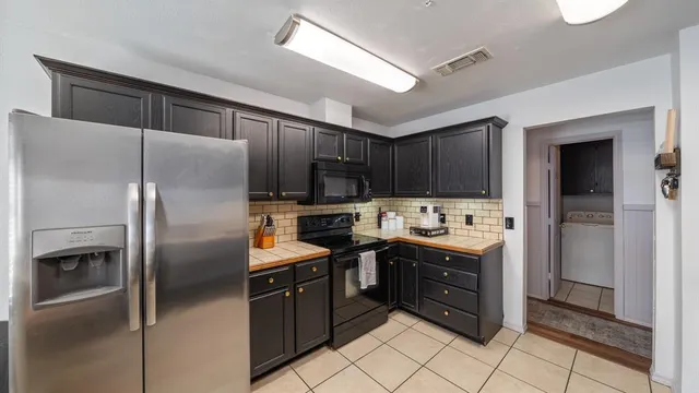 a kitchen with stainless steel appliances granite countertop a refrigerator and a stove