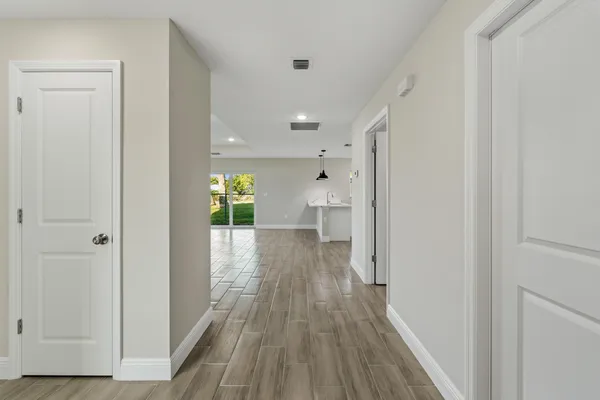 a view of kitchen with kitchen island white cabinets and wooden floor