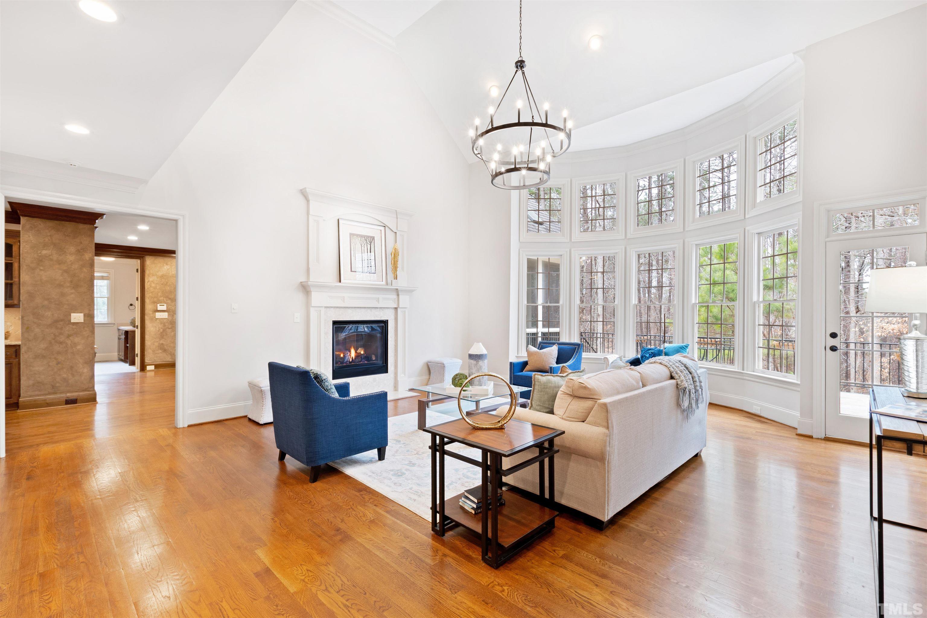 1313 Caistor Lane Raleigh, NC 27614 - Photo 28 of 84 a living room with furniture a fireplace and a chandelier
